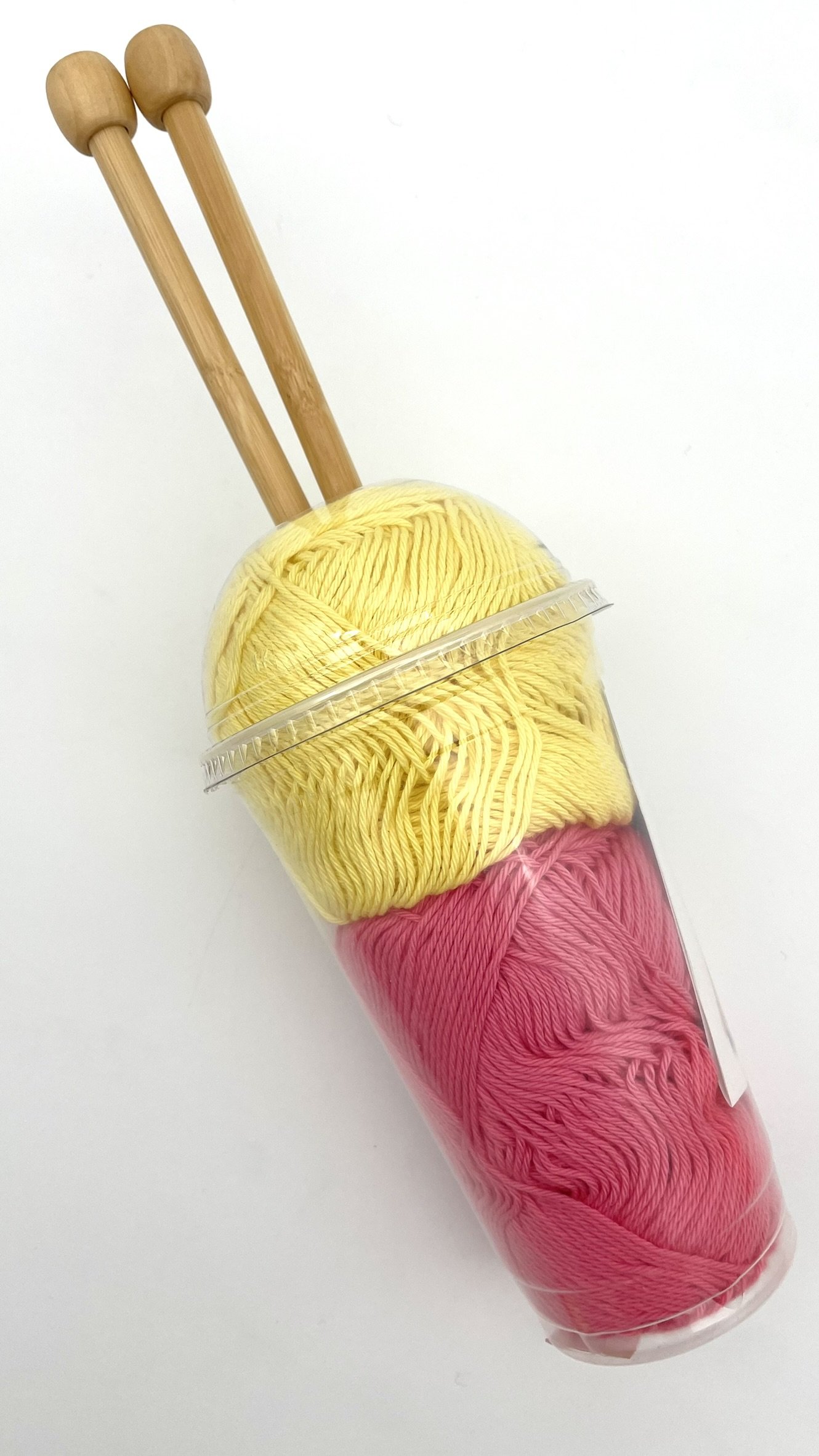 DIY Smoothie Scarf kit in yellow and pink with bamboo knitting needles back view.