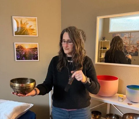 A cozy bedroom with a bed, decorative lamps, and wall art, illuminated by string lights and fairy lights.