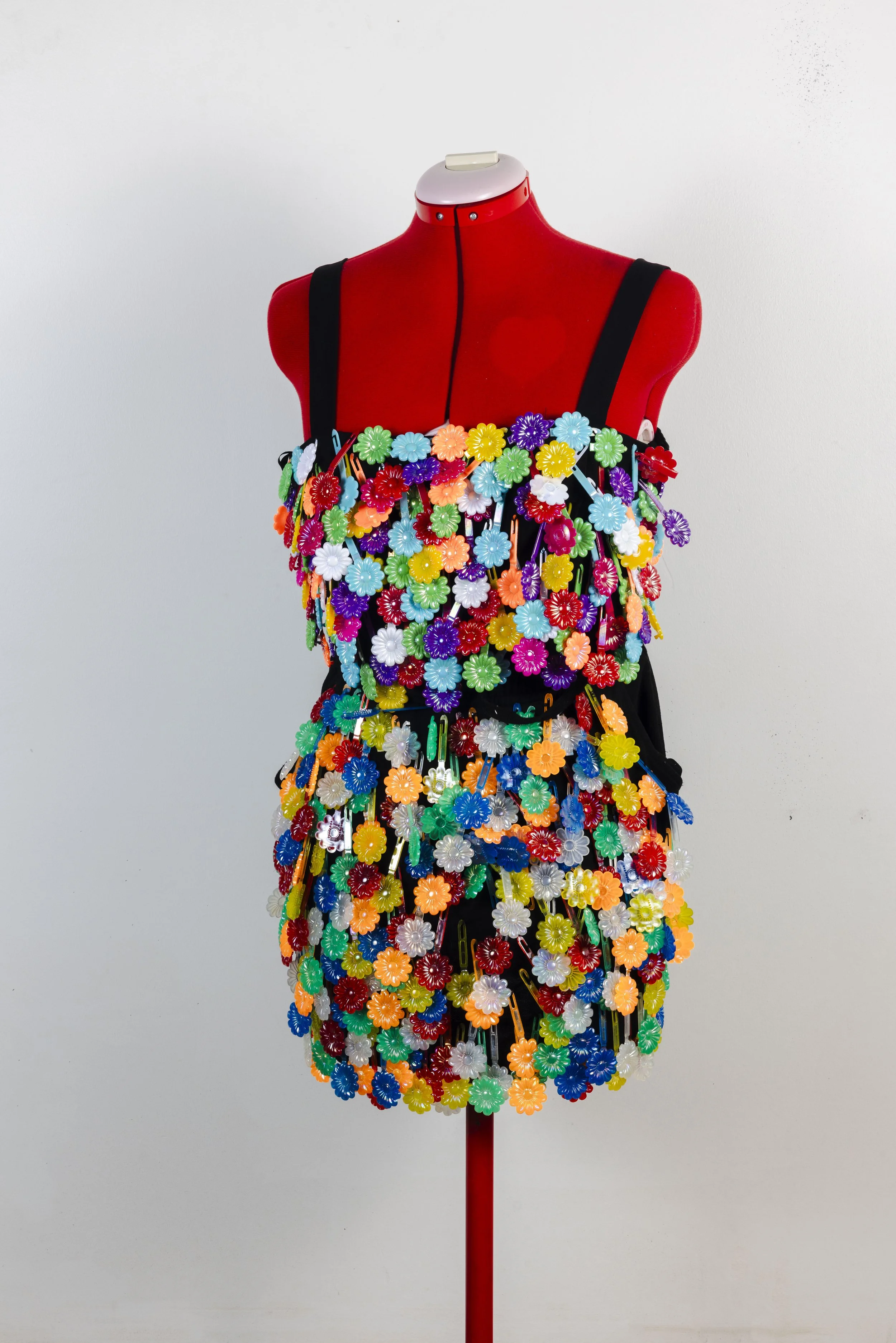 “Play Time”
Handcrafted for the GRWM Runway Collection, this piece is made from secondhand textiles and adorned with colorful hair barrettes. The garment embodies Imani’s inner child, with each hand-sewn barrette symbolizing the joy and playful energ