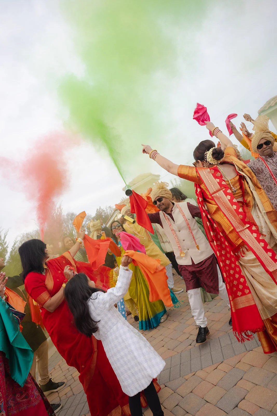 People celebrating during an Indian festival, throwing colorful powders and smoke, dressed in traditional Indian attire.