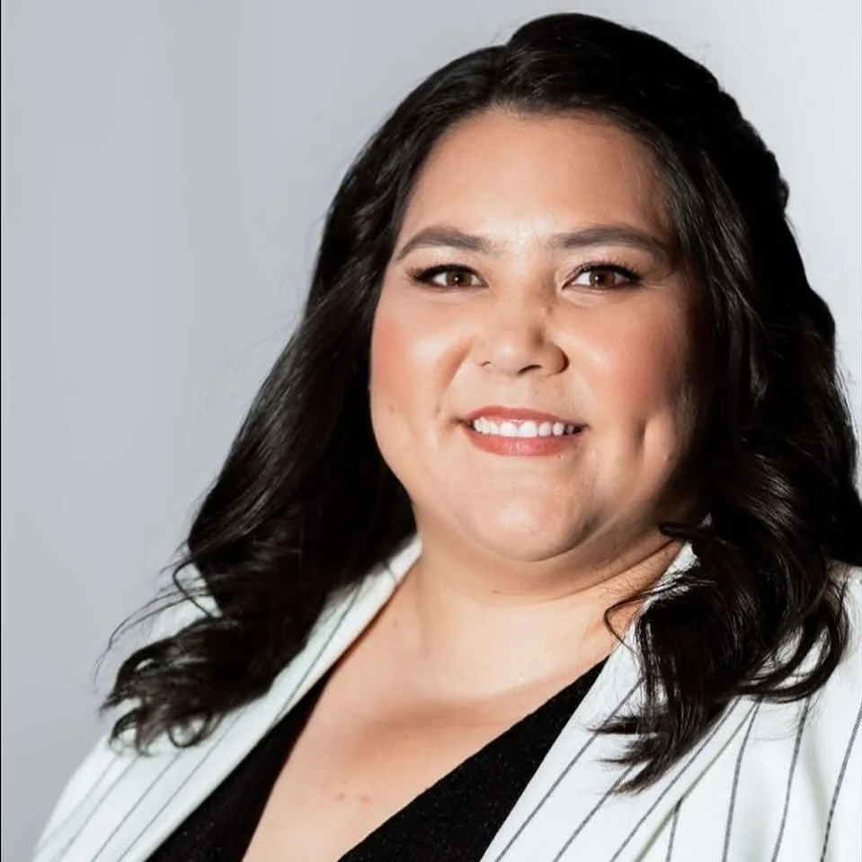 A single pink and white flower with a green center and stem against a light blue background.
