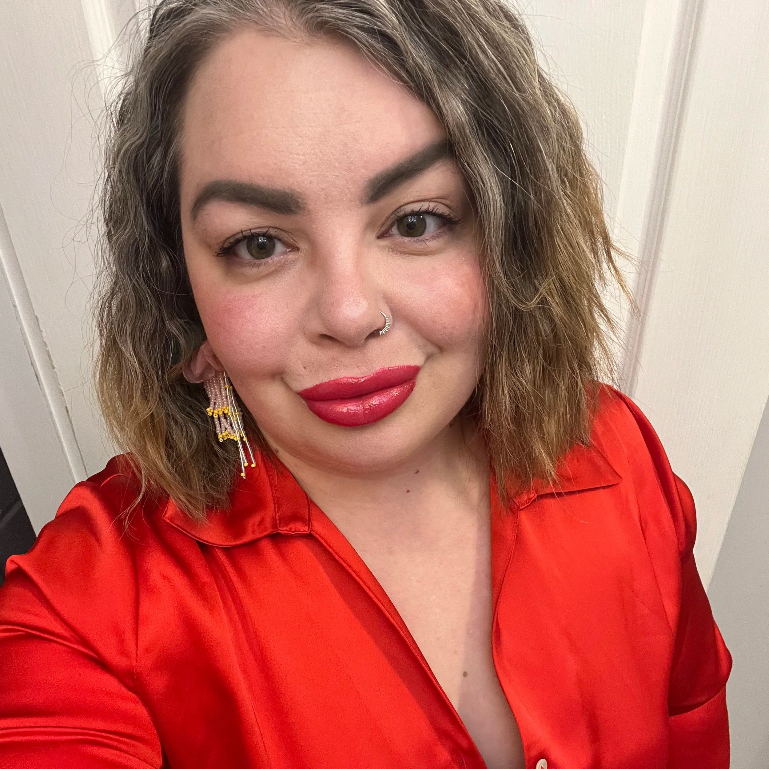 A close-up of a pink gerbera daisy flower on a green stem against a light blue background.