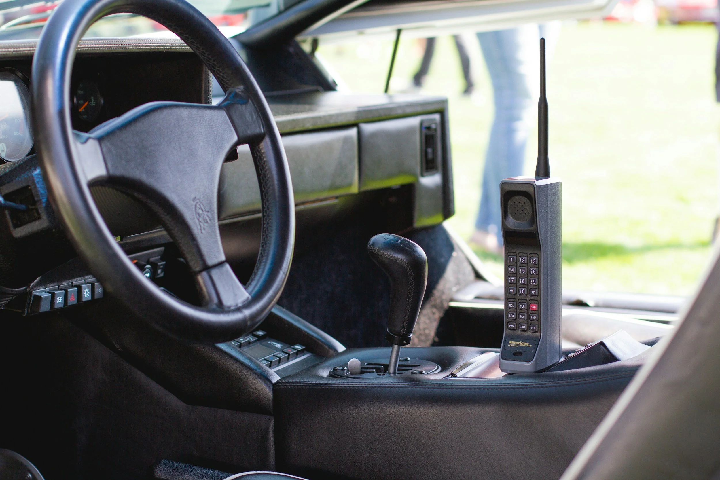 Interior de un vehículo clásico, con volante, tablero y un radio transceptor en el tablero.