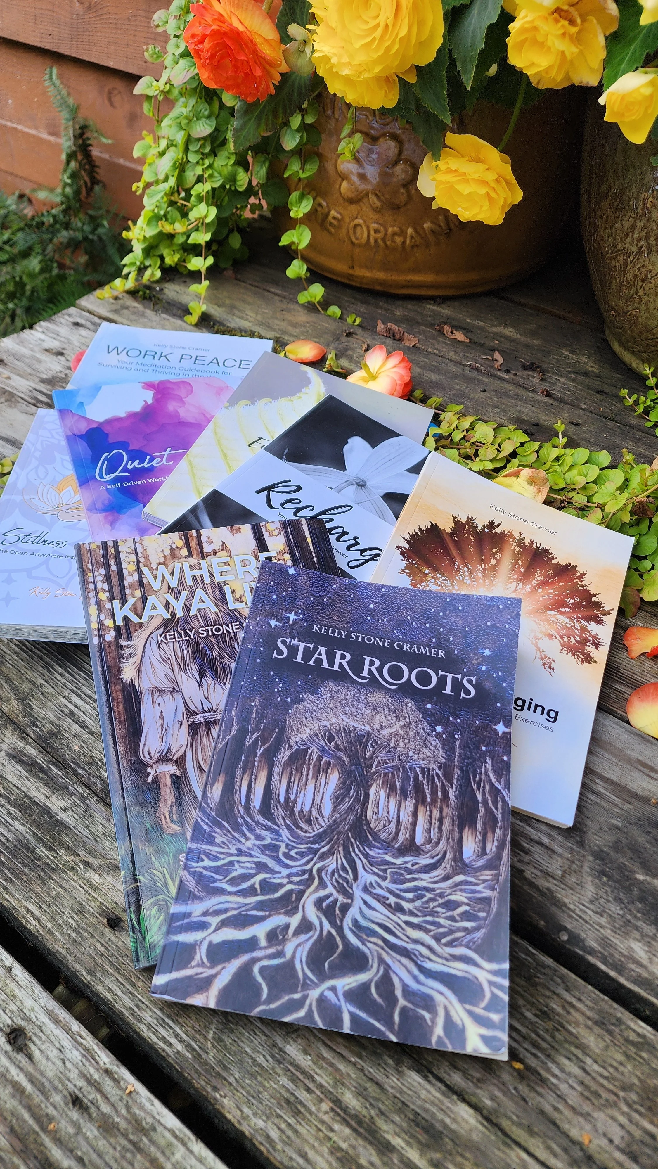 Several self-help and meditation books laid out on a soft, pink, textured fabric surface. Titles include "Work Peace," "Gentle Recharging," "Peaceful Empowerment," and "Gratitude & Growth".