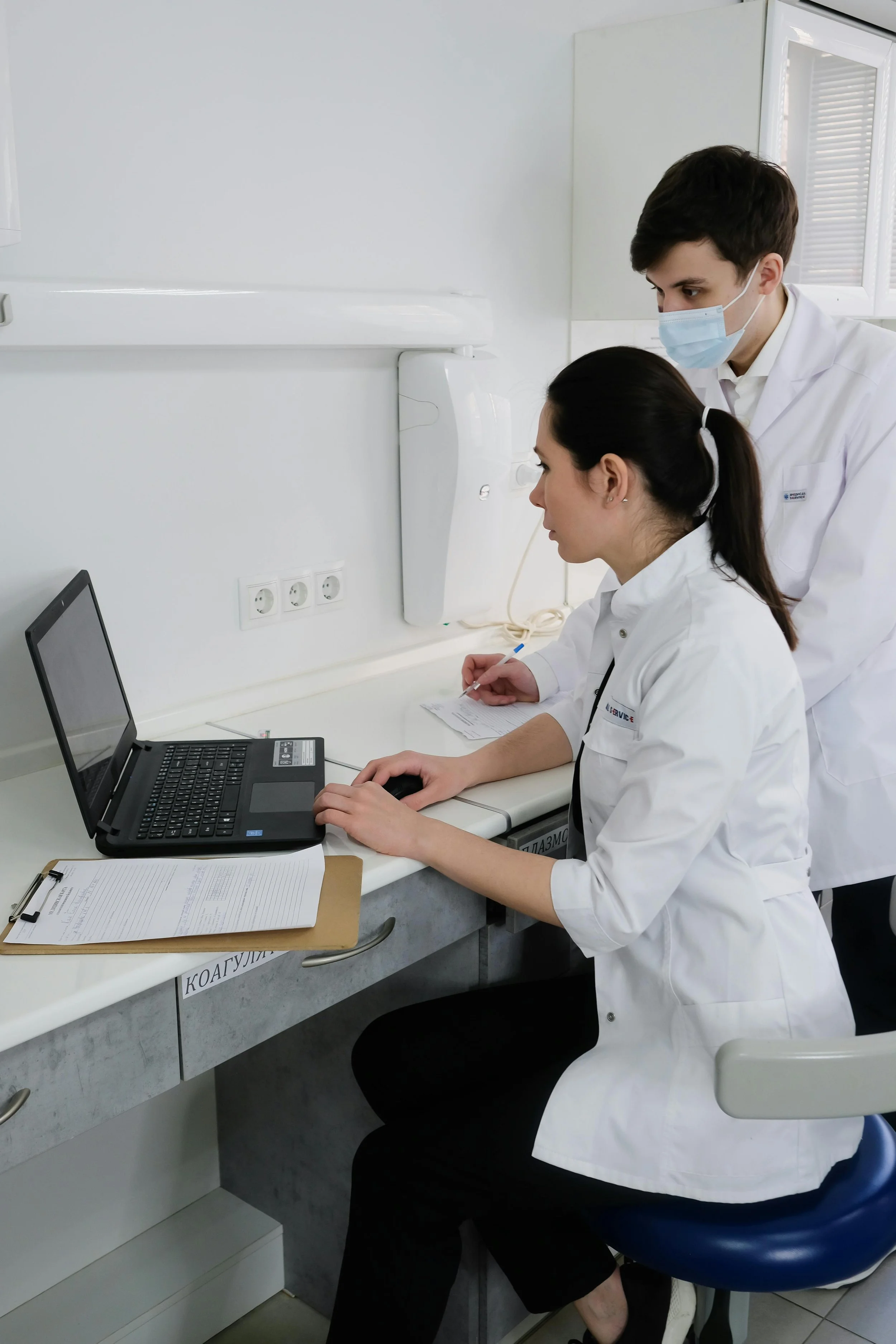 Doctors working together on a laptop in a medical clinic, representing team-based healthcare and GP services in Sydney