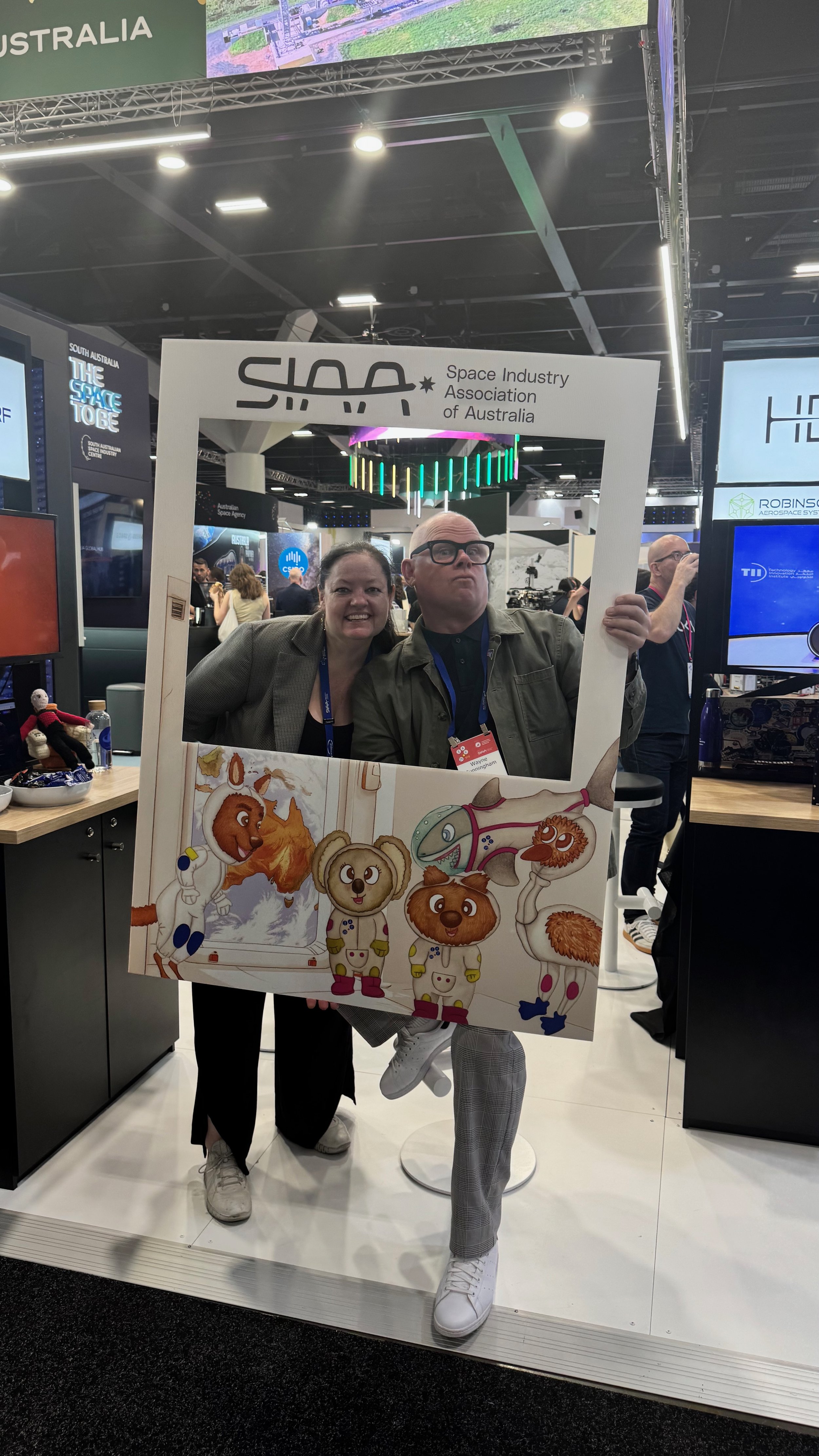 Wayne Cunningham and Kelly Yeoh holding a Space Industry Association of Australia photo frame at the International Astronautical Congress (IAC 2025) in Sydney