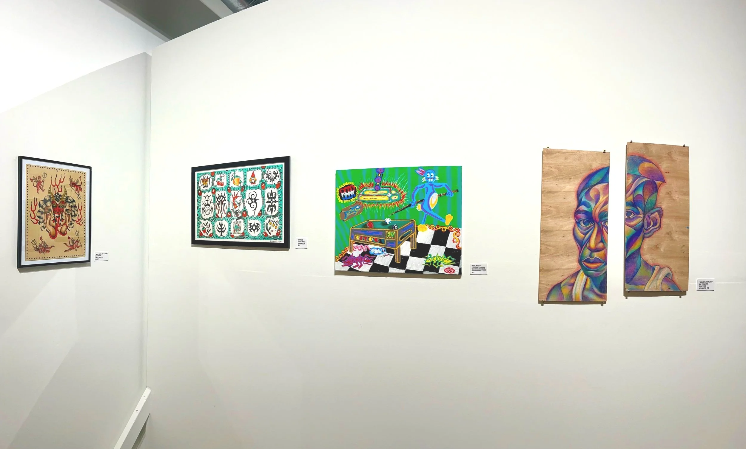 Exhibit wall with five colorful artworks displayed in a gallery, including abstract, cartoonish, and portrait styles.
