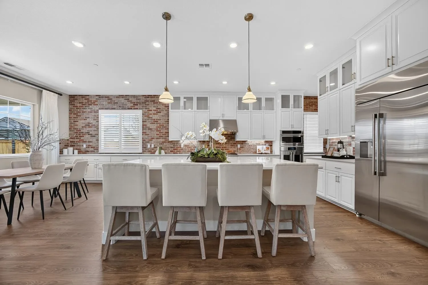 open luxury kitchen and dining area with counter pendant lighting and neutral tones stool is Lincoln California  