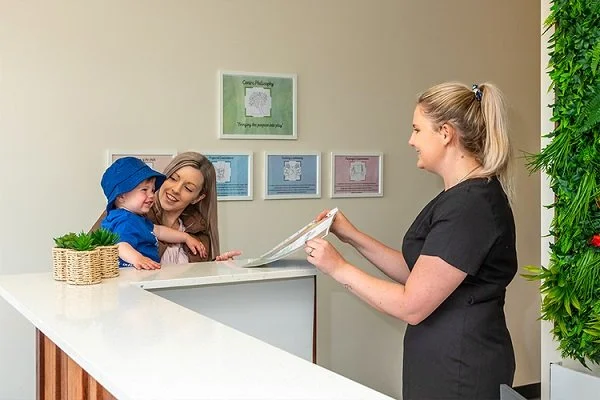 Educator greets parent and child at the reception desk at Highfields Central Early Learning Centre