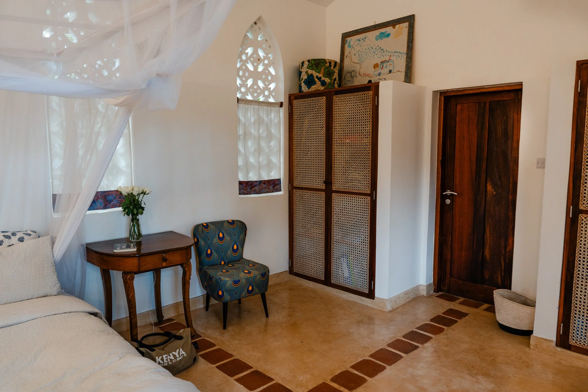 The upstairs master bedroom features a king-size bed, ceiling and standing fan, a writers desk, cupboard space and en-suite bathroom.