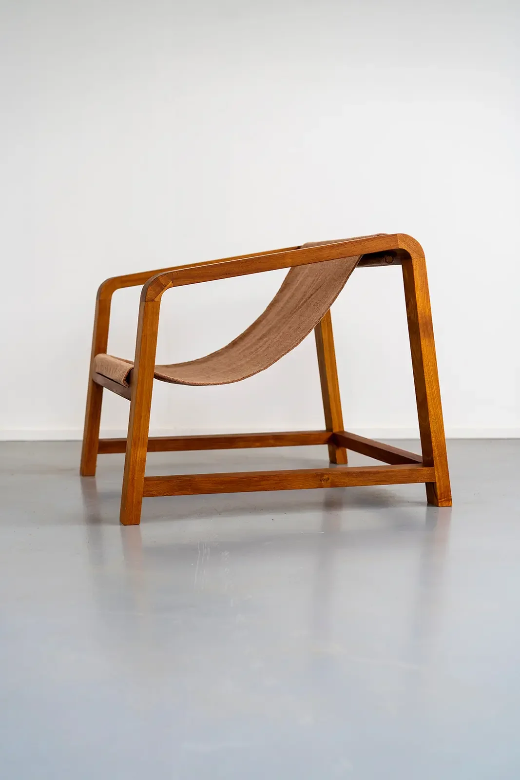 Wrangler chair in Tasmanian Blackwood and ochre velour sling. Side on view, highlighting the soft curved edges and detail in the wood grain. Hand made on the Surf Coast by Georgie Wood. 