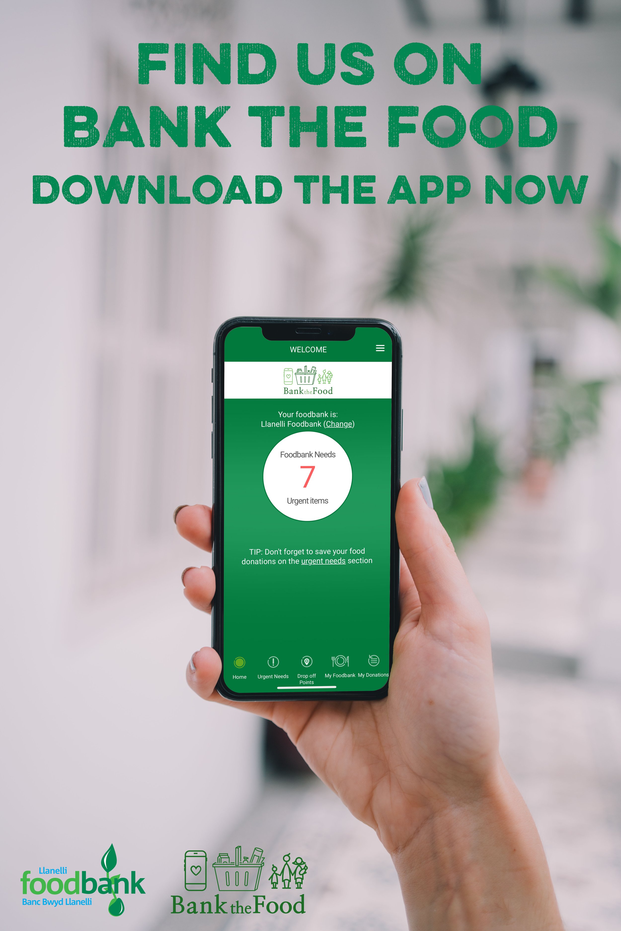 A person holding a smartphone displaying the Bank the Food app with a screen showing 7 urgent food needs. The background is blurred, and there is text at the top that says "FIND US ON BANK THE FOOD DOWNLOAD THE APP NOW." There are logos for Llanelli Foodbank and Bank the Food at the bottom left of the image.