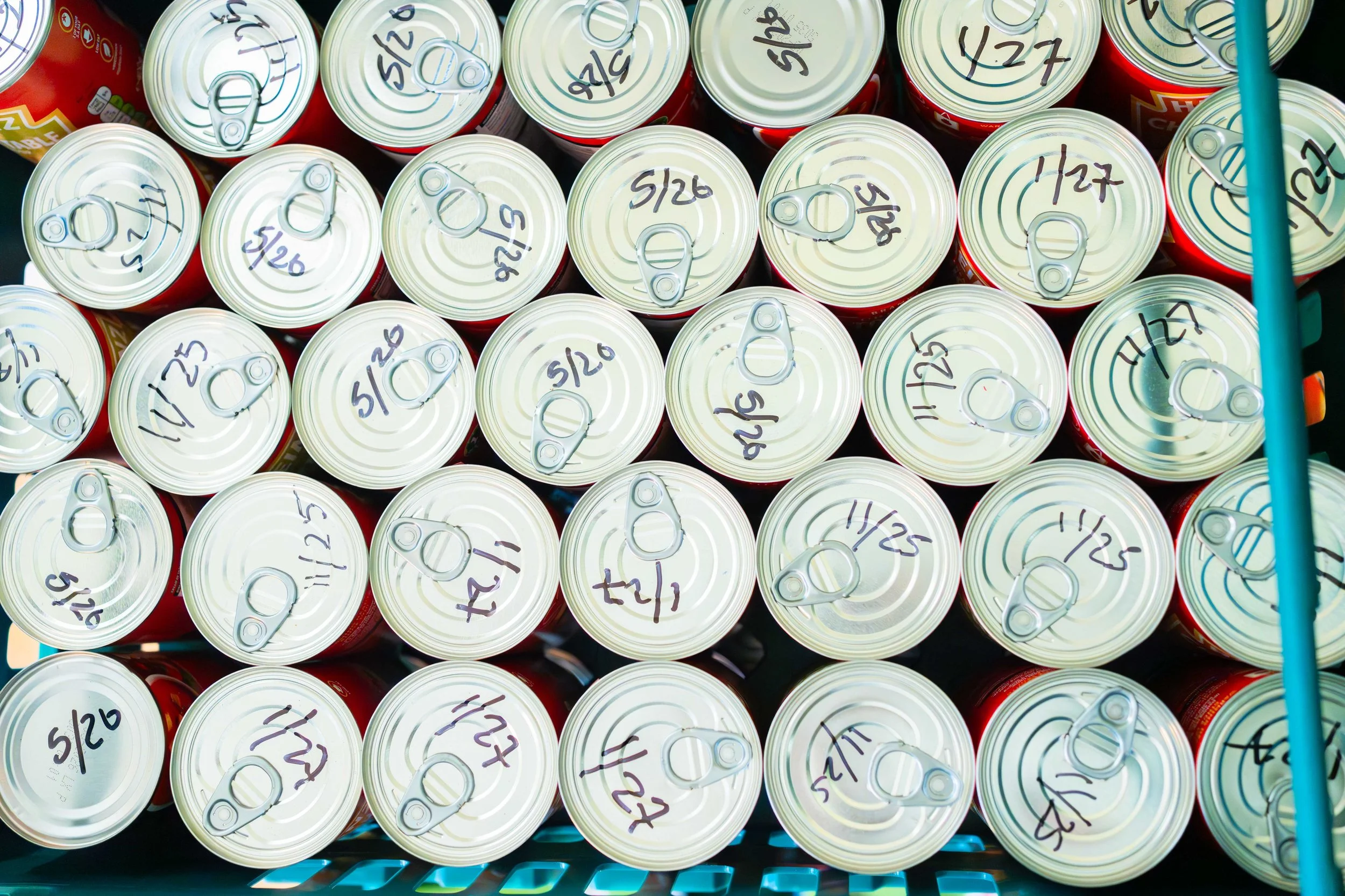 A cart filled with cans labeled with dates, viewed from above.