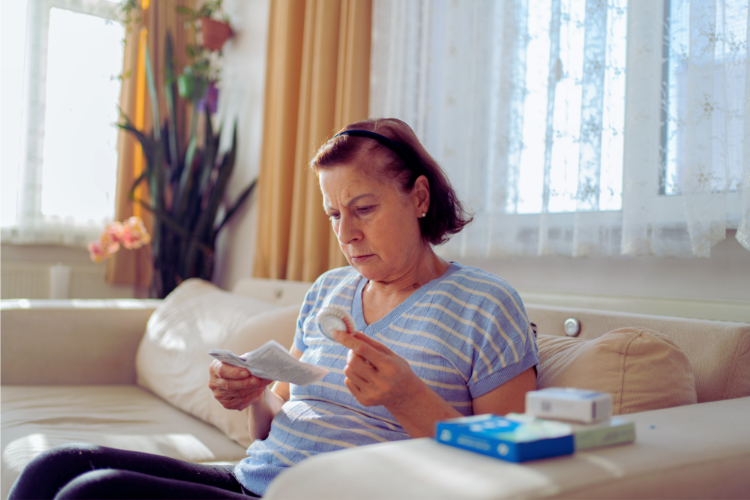 Woman at home reading a prescription medication leaflet
