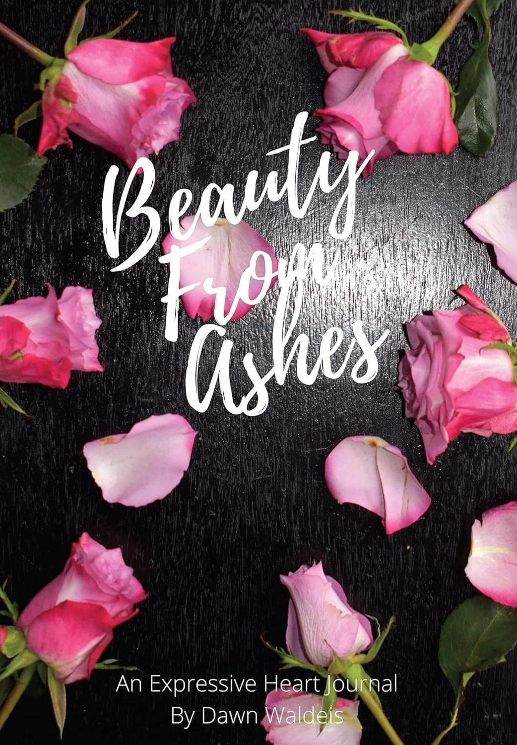 Cover of "Beauty From Ashes: An Expressive Heart Journal by Dawn Waldeis" featuring pink roses and petals on black background.