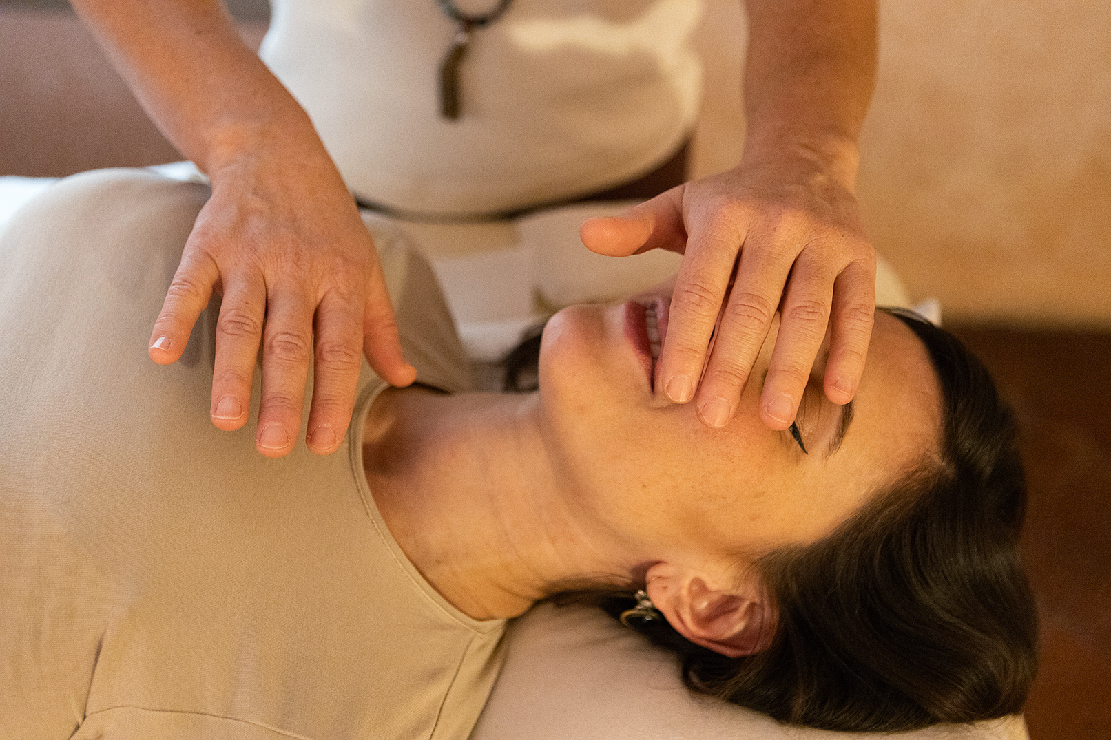 mani del pranoterapeuta sospese sul corpo di una donna durante una seduta di pranoterapia