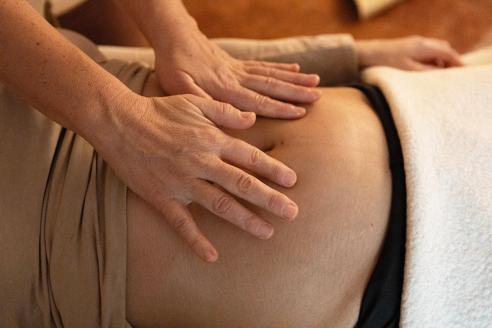 Una persona riceve un massaggio sulla schiena, con le mani posizionate sulla zona lombare.