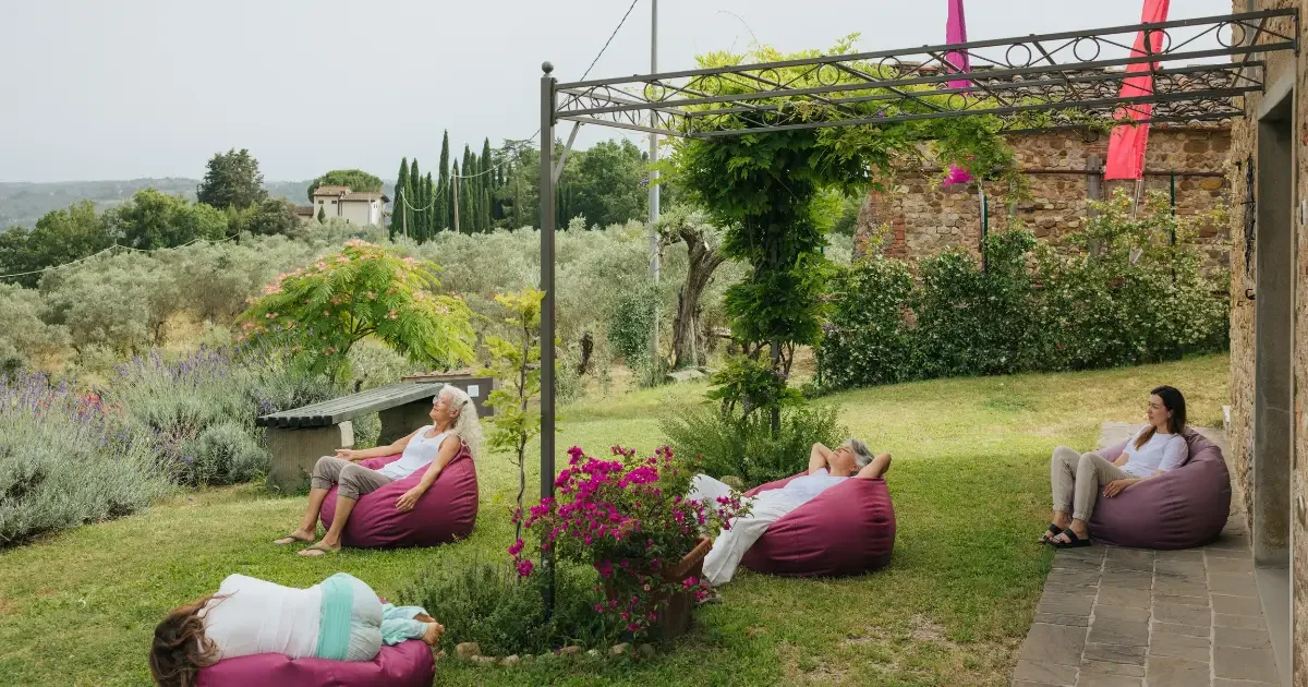 Seeds: One day Retreat: quattro persone rilassate sedute su poltrone a sacco rosa nel giardino della sorripa
