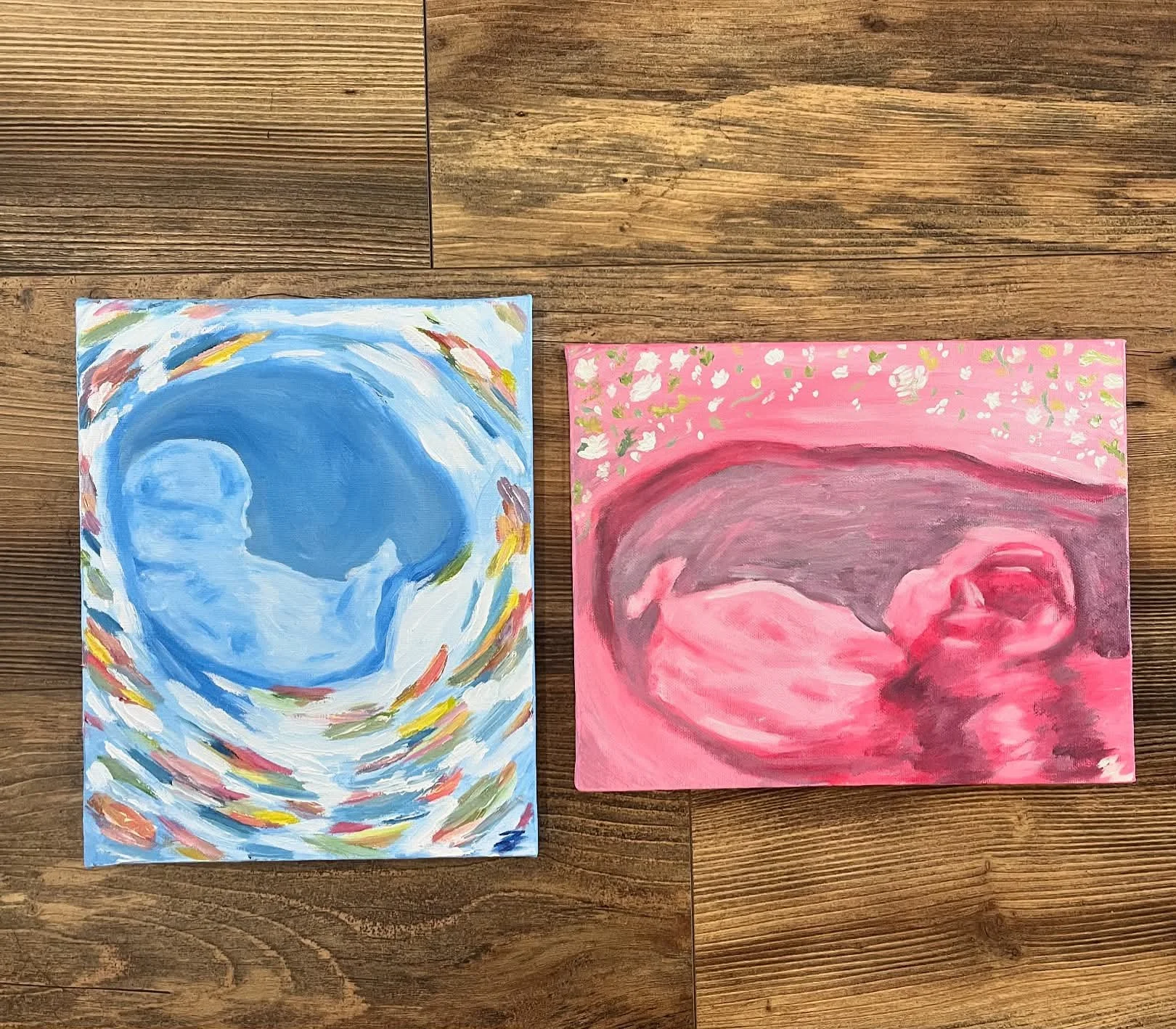 Two abstract paintings of ultrasounds, one with blue swirls and the other with pink.