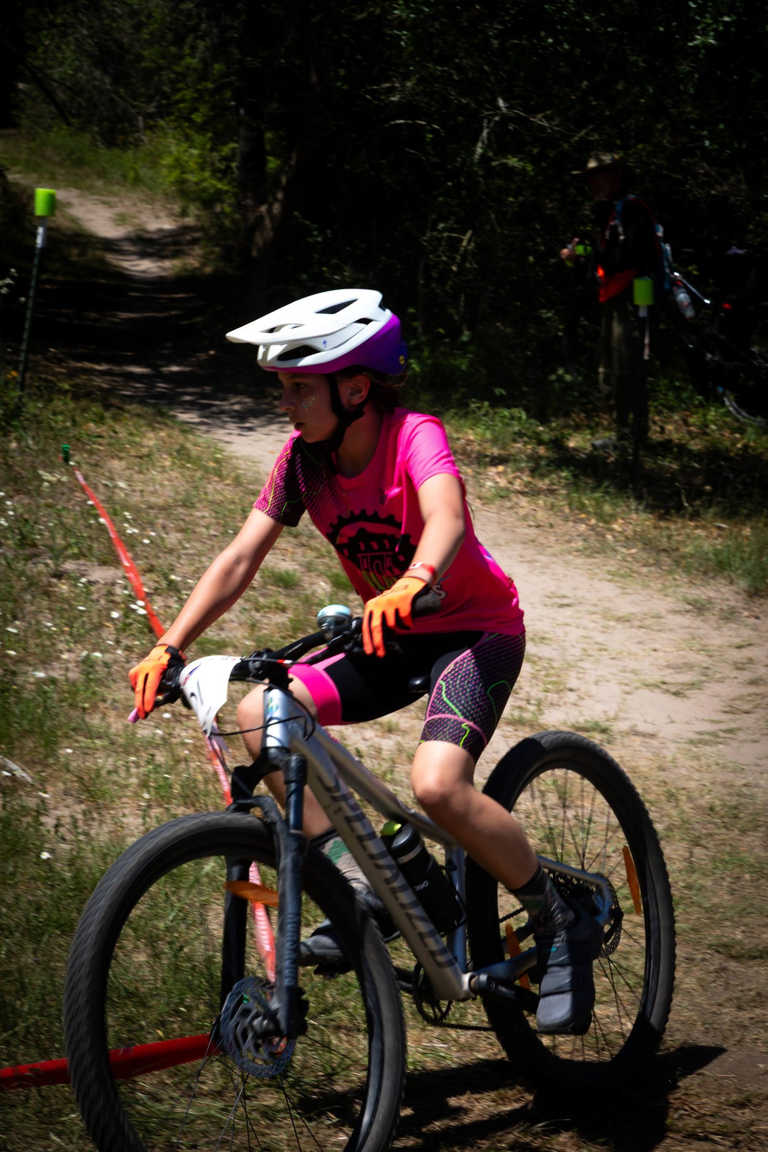 An Alamo City Femmes rider racing on a dirt trail