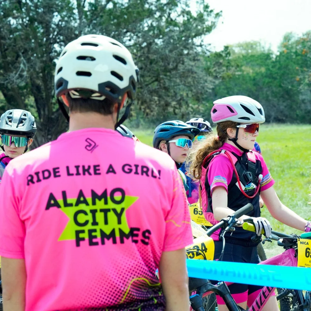 The back of a pink team jersey reading Ride like a girl, Alamo City Femmes