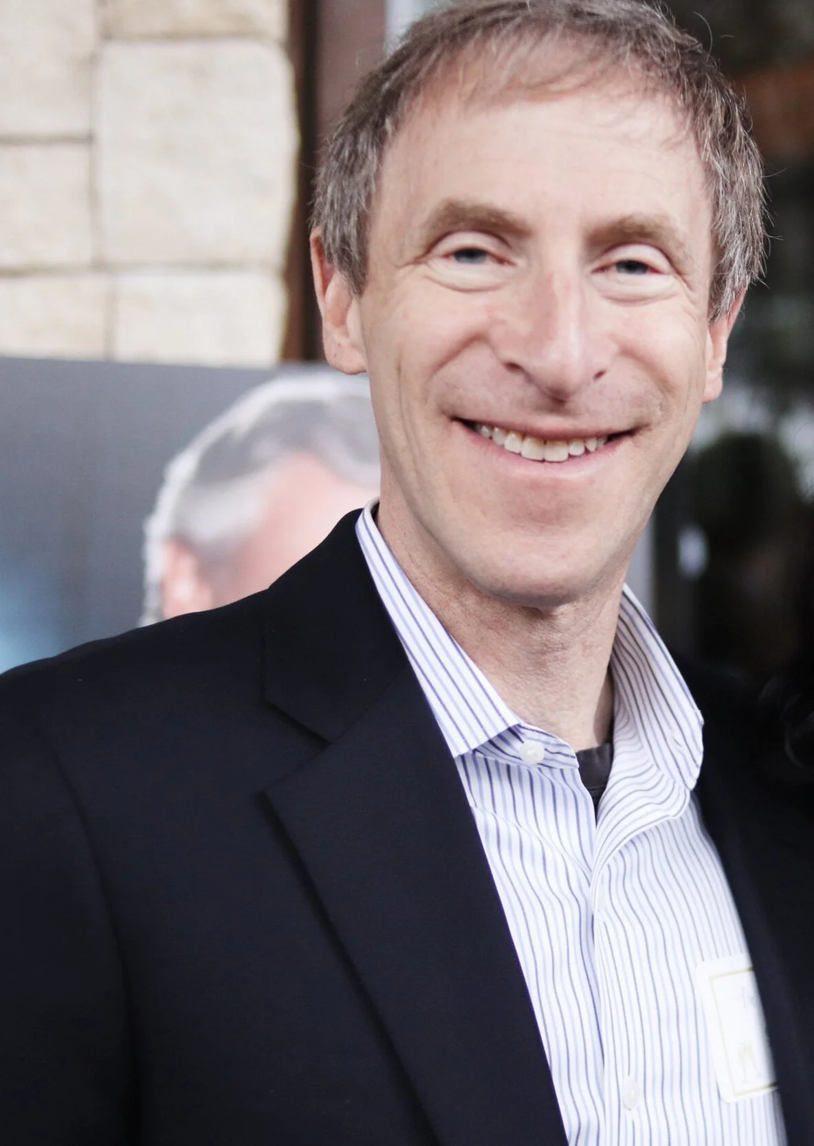 A smiling man in a suit and striped shirt