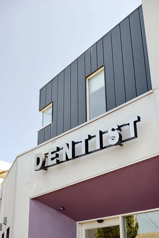 Exterior of a modern dentist office with a sign reading 'DENTIST' on the building. New Street Brighton