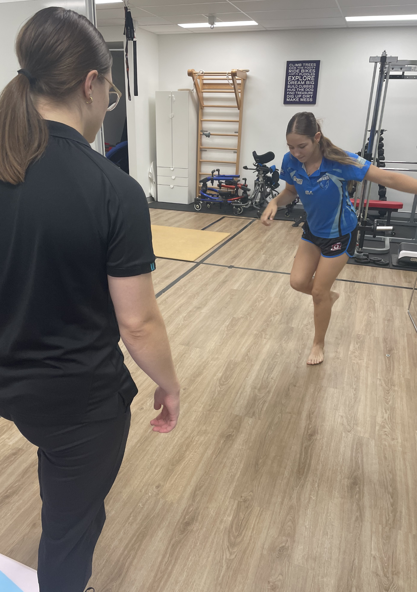 Paediatric physiotherapist assessing balance and movement control in a young athlete