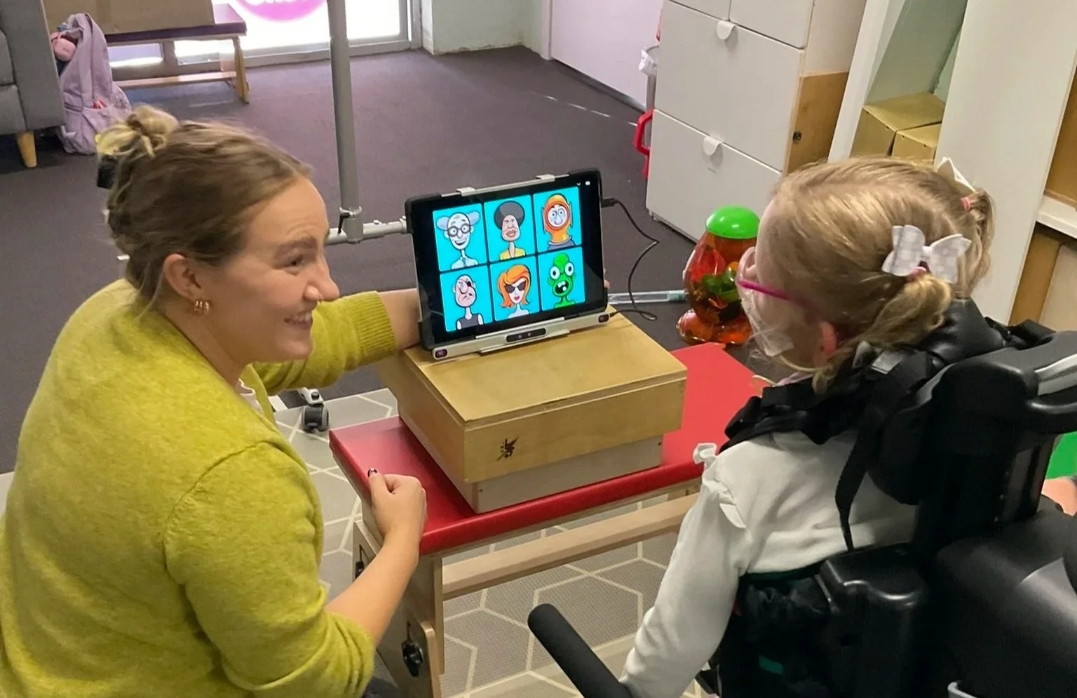 Child using augmentative and alternative communication with support from a speech pathologist