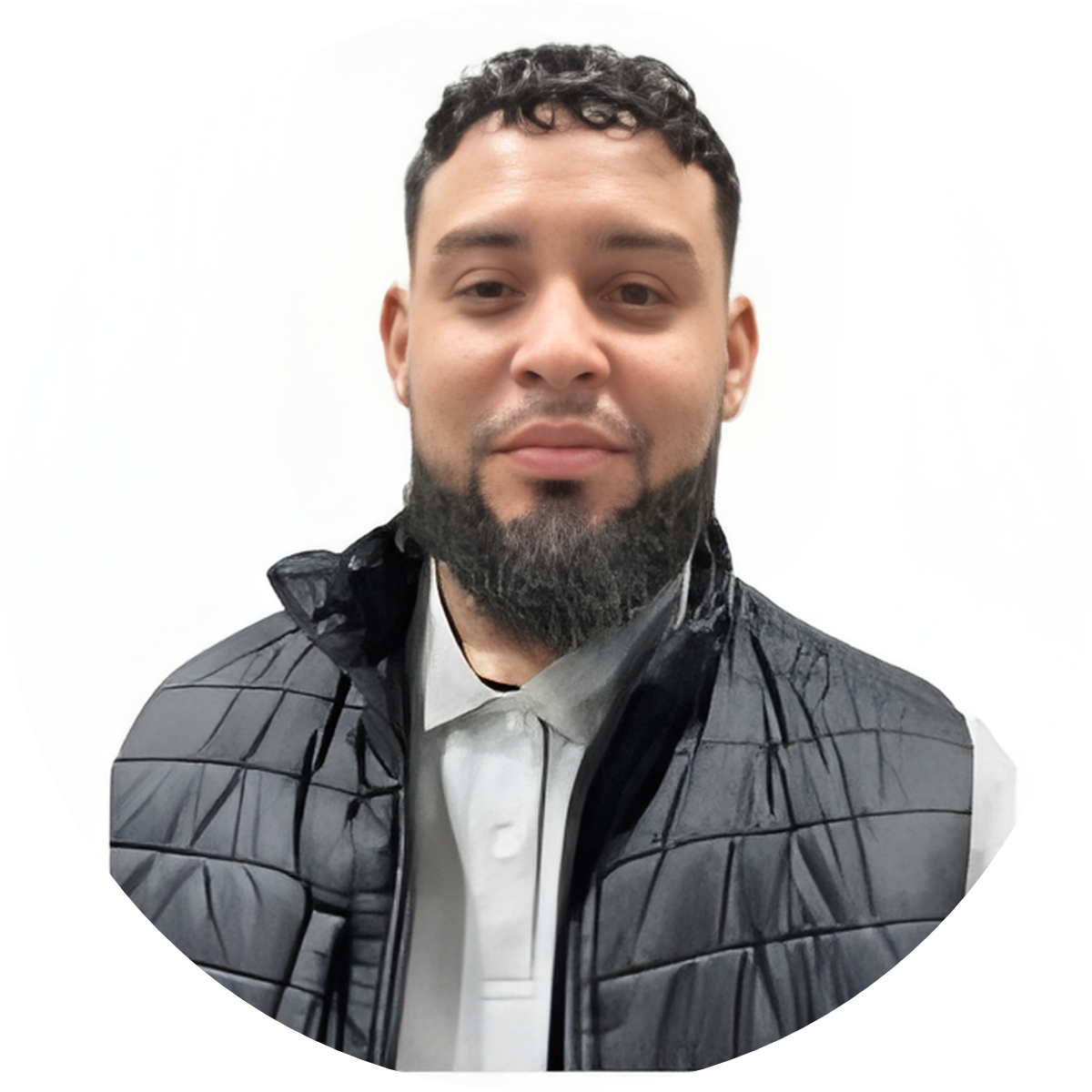 Portrait of a man with a beard wearing a white collared shirt and a black puffer vest, standing against a plain white background.