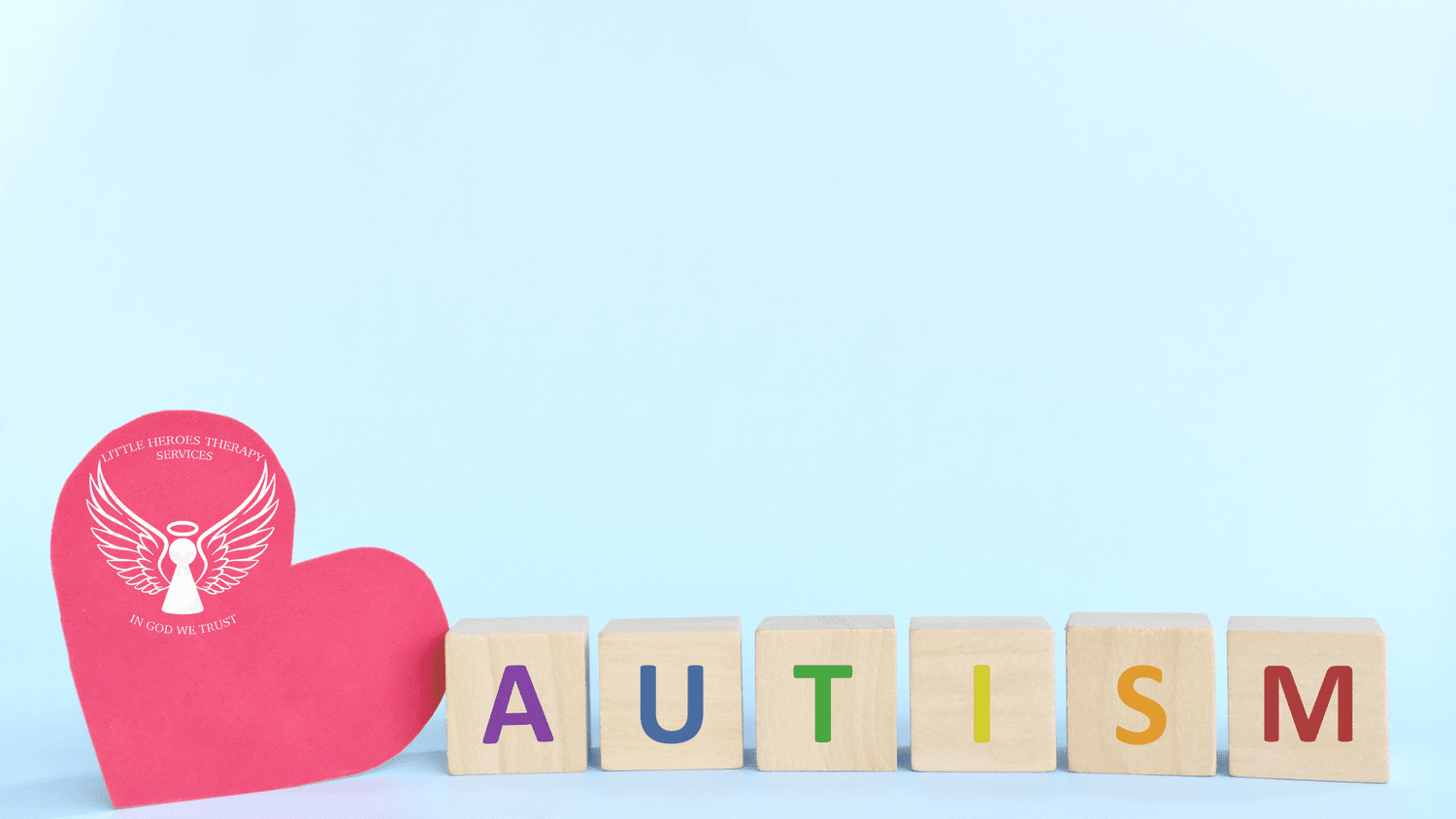 Wooden blocks spelling AUTISM next to a heart