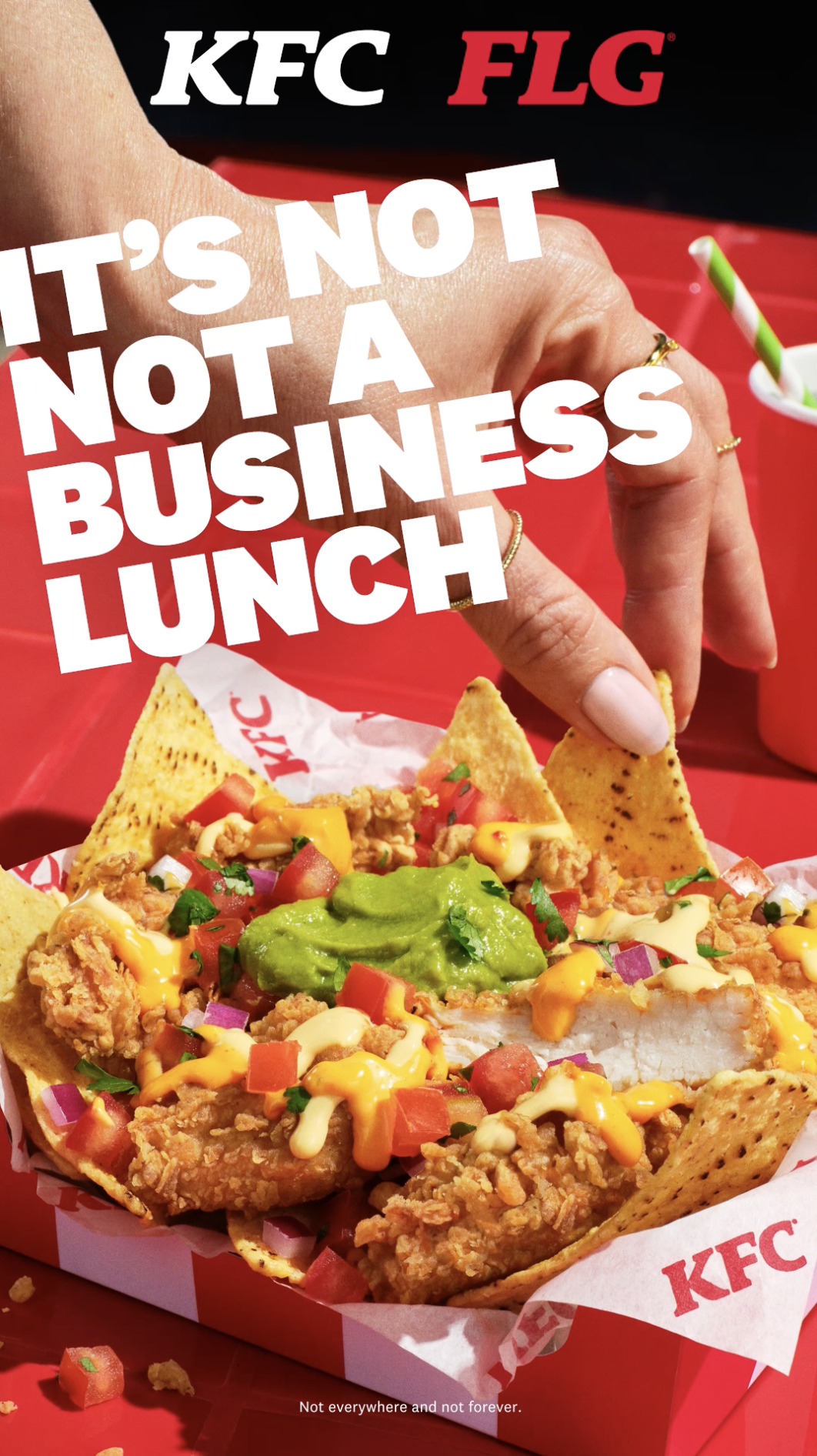 Close-up of a KFC fried chicken taco in a red and white container, topped with guacamole, diced tomatoes, onions, cheese, and tortilla chips, with a person's hand reaching to grab a chip in the background.