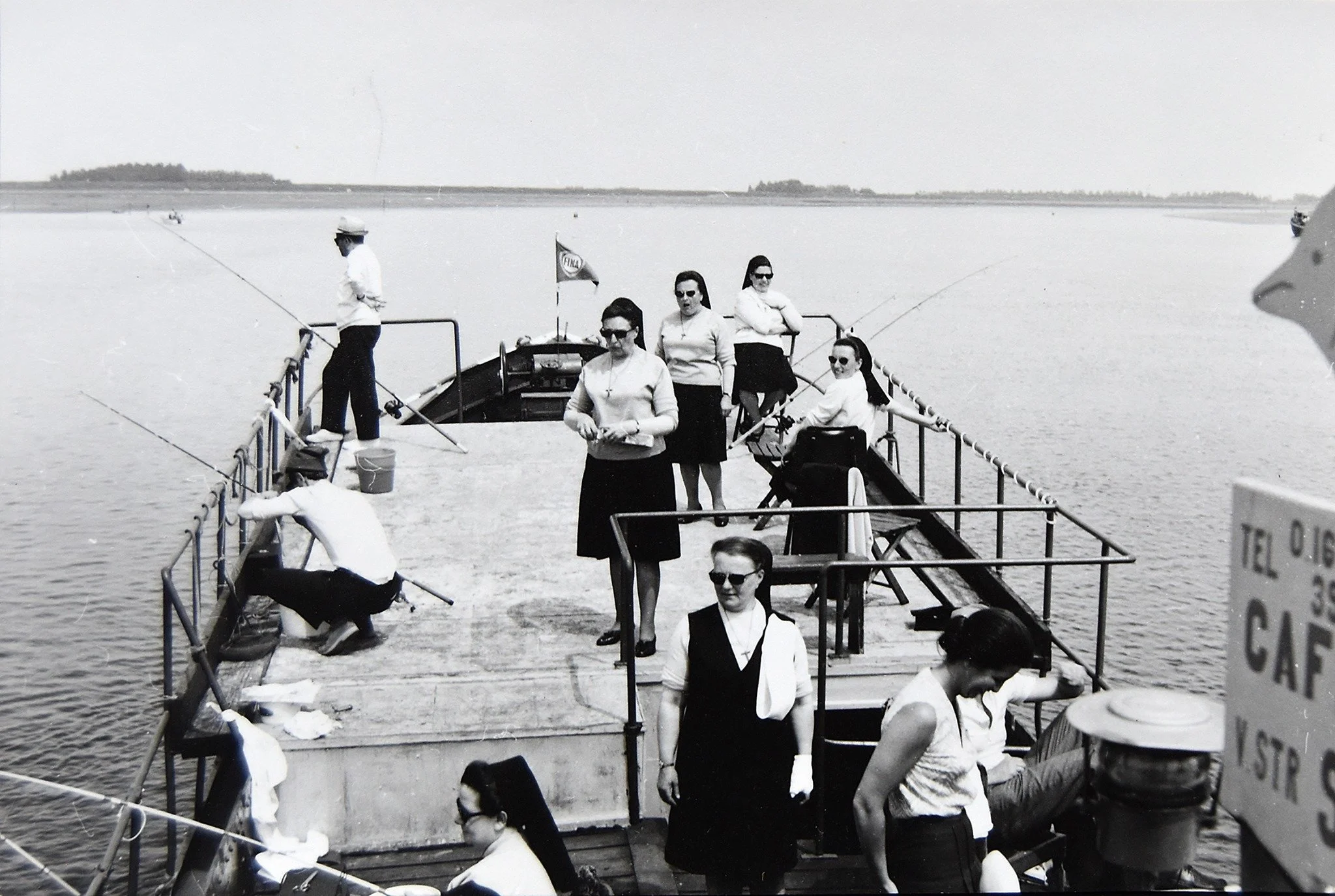   Zuster Gabriëlla met een vislijn in de hand (vooraan). Miel Vanneste en René Van Parijs, eveneens met een lijn in de hand. Zuster Poldine (centraal vooraan), Ann Willems, zusters Edmonda, Genna, Maria en Pia kijken toe.  