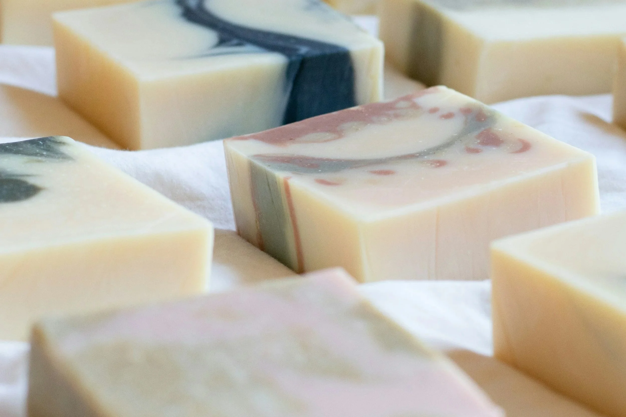Colourful Natural soap bars arranged on a neutral surface.