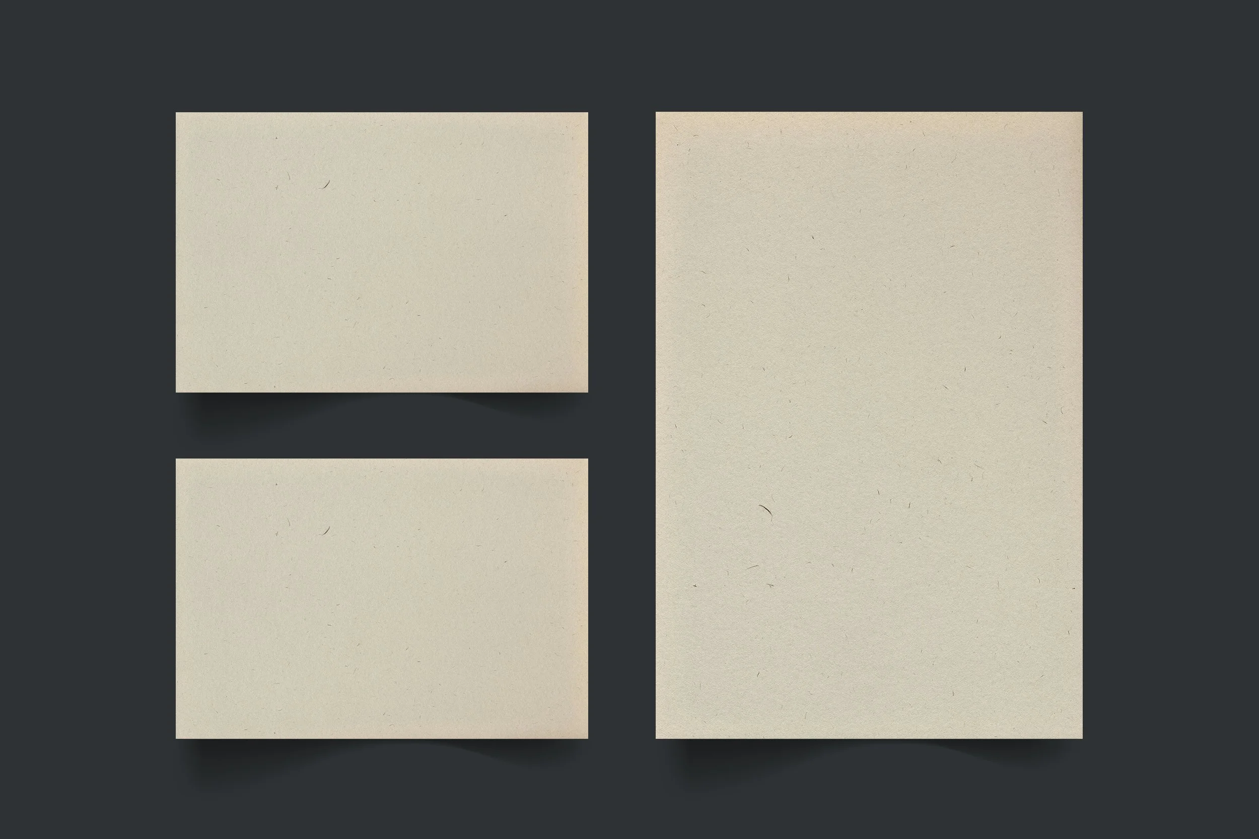 Three blank beige cards of different sizes on a dark gray background, with the smallest above the medium and the largest to the right.