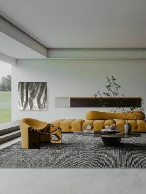 Sala moderna con sillón amarillo, sillón de plástico y mesa de centro negra sobre alfombra gris, en una casa con vista al exterior
