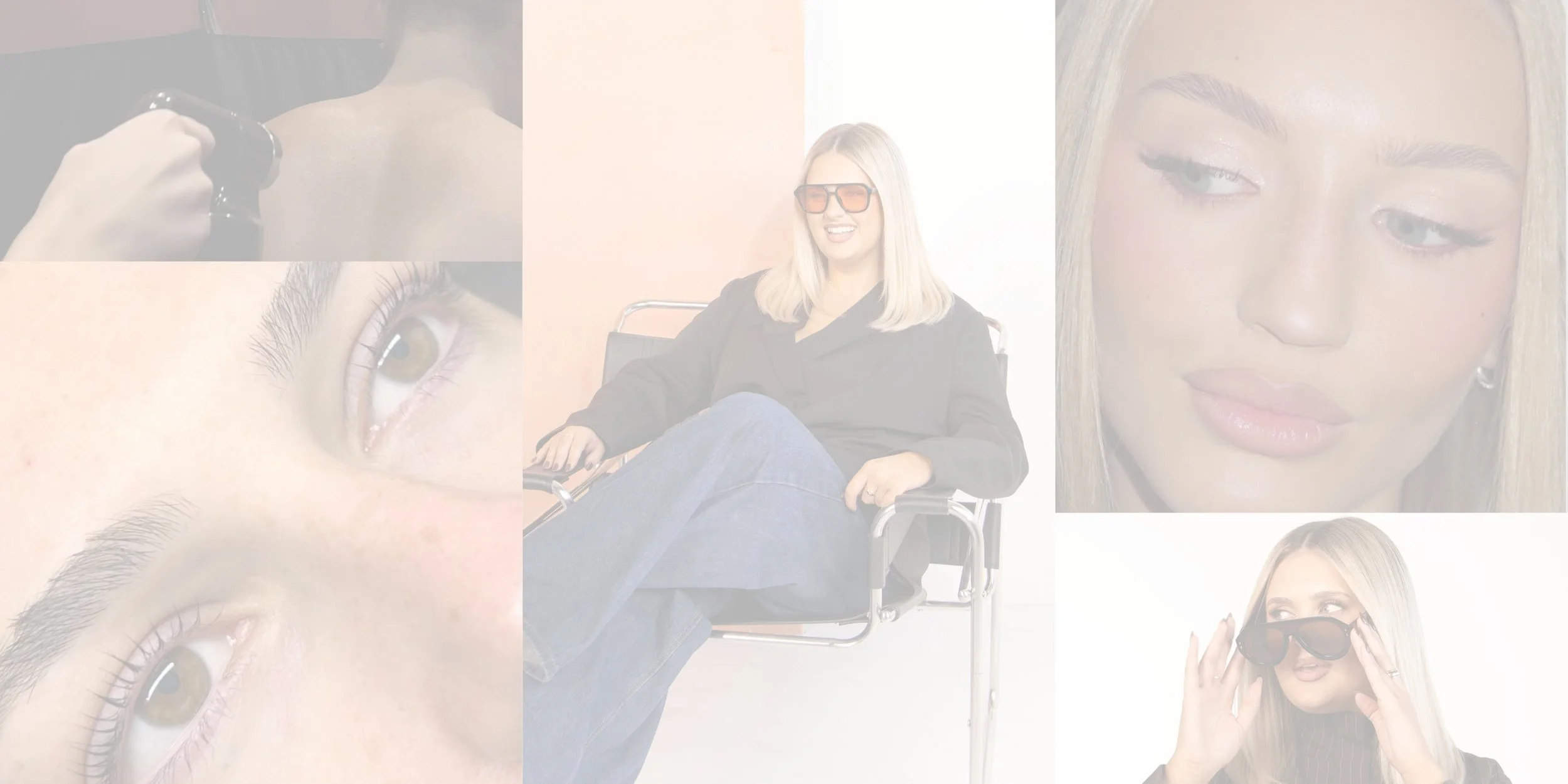 A woman with blonde hair wearing sunglasses and a black jacket sitting in a wheelchair, smiling in a bright setting with a plain background.