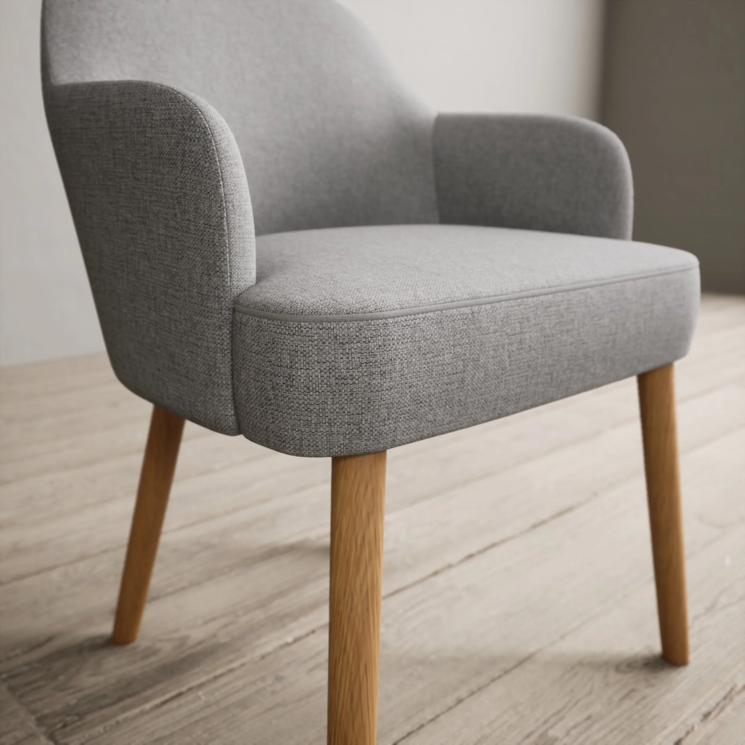 A modern gray upholstered armchair with wooden legs on a light wood floor.