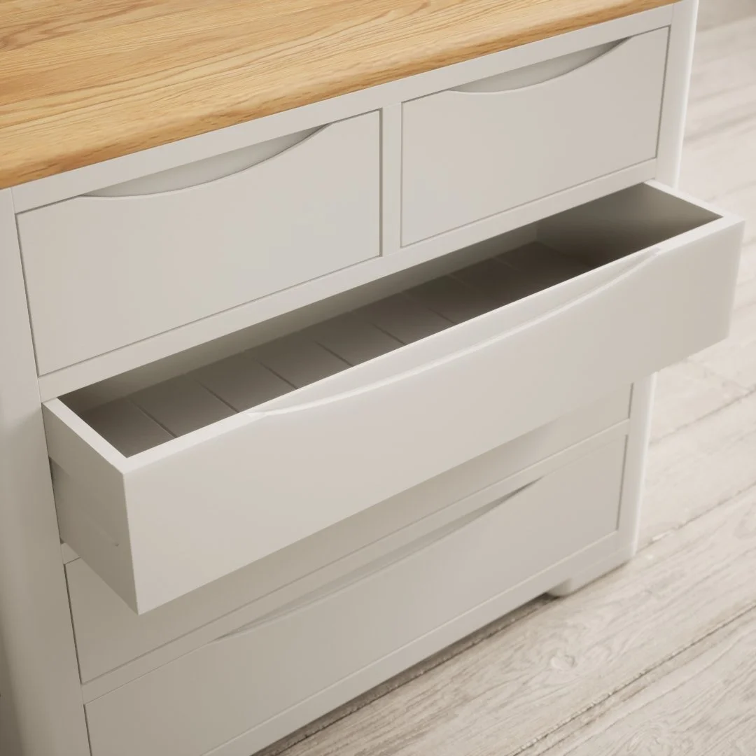 White wooden dresser with two small top drawers, an open middle drawer, and larger bottom drawer, all with simple panel design, on a light wood floor.