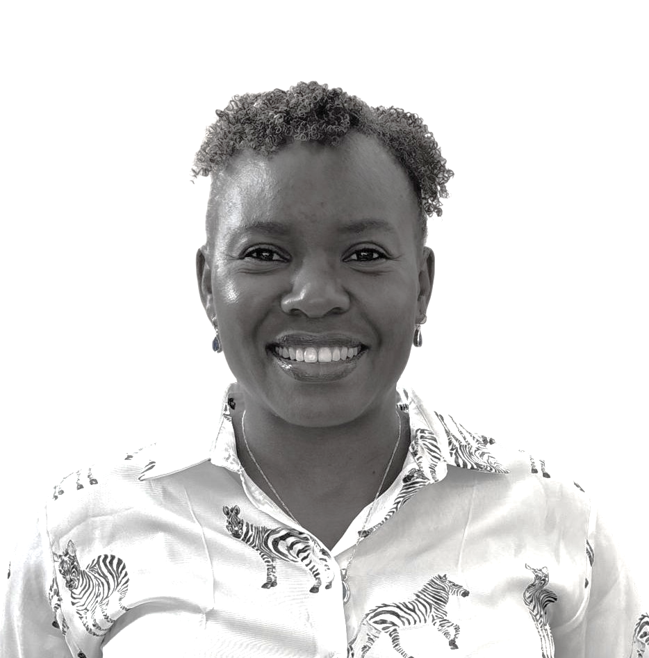 Black and white portrait of a woman smiling, wearing a shirt with zebra print and earrings.