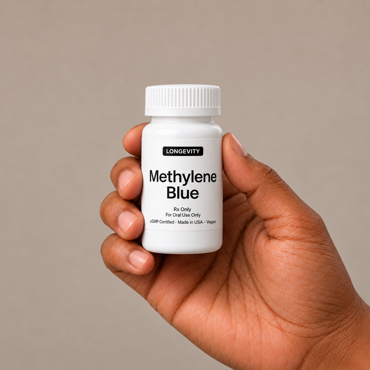A white pill bottle labeled 'Lovely Meds Methylene Blue' held against a brown background.