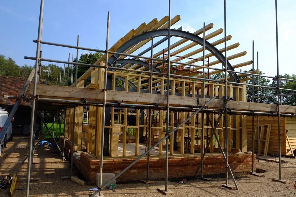 Construction site of a house with wooden framing and scaffolding in place.
