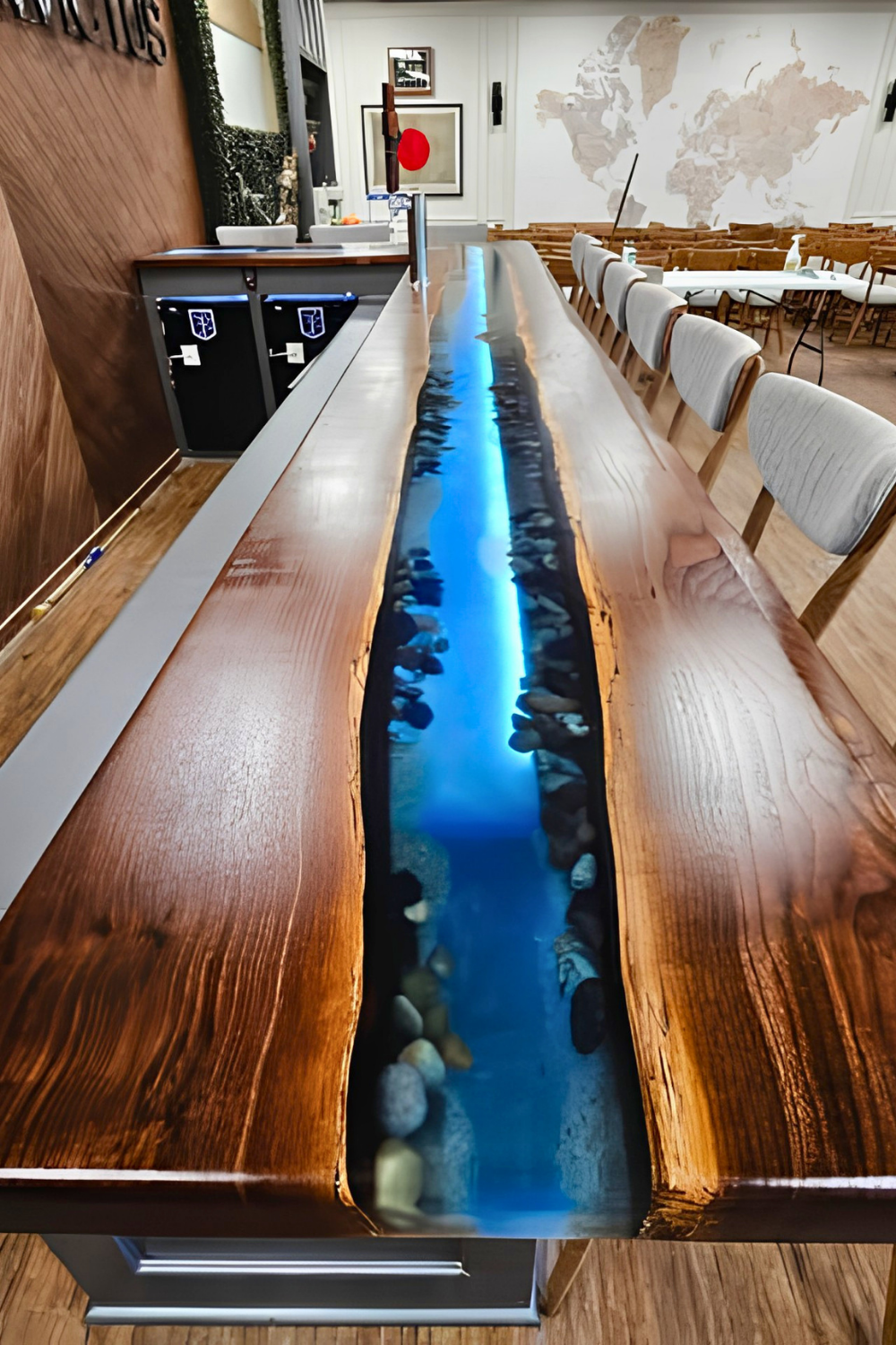 Long wooden conference table with a blue lit resin river centerpiece running through the middle, surrounded by chairs in a meeting room.