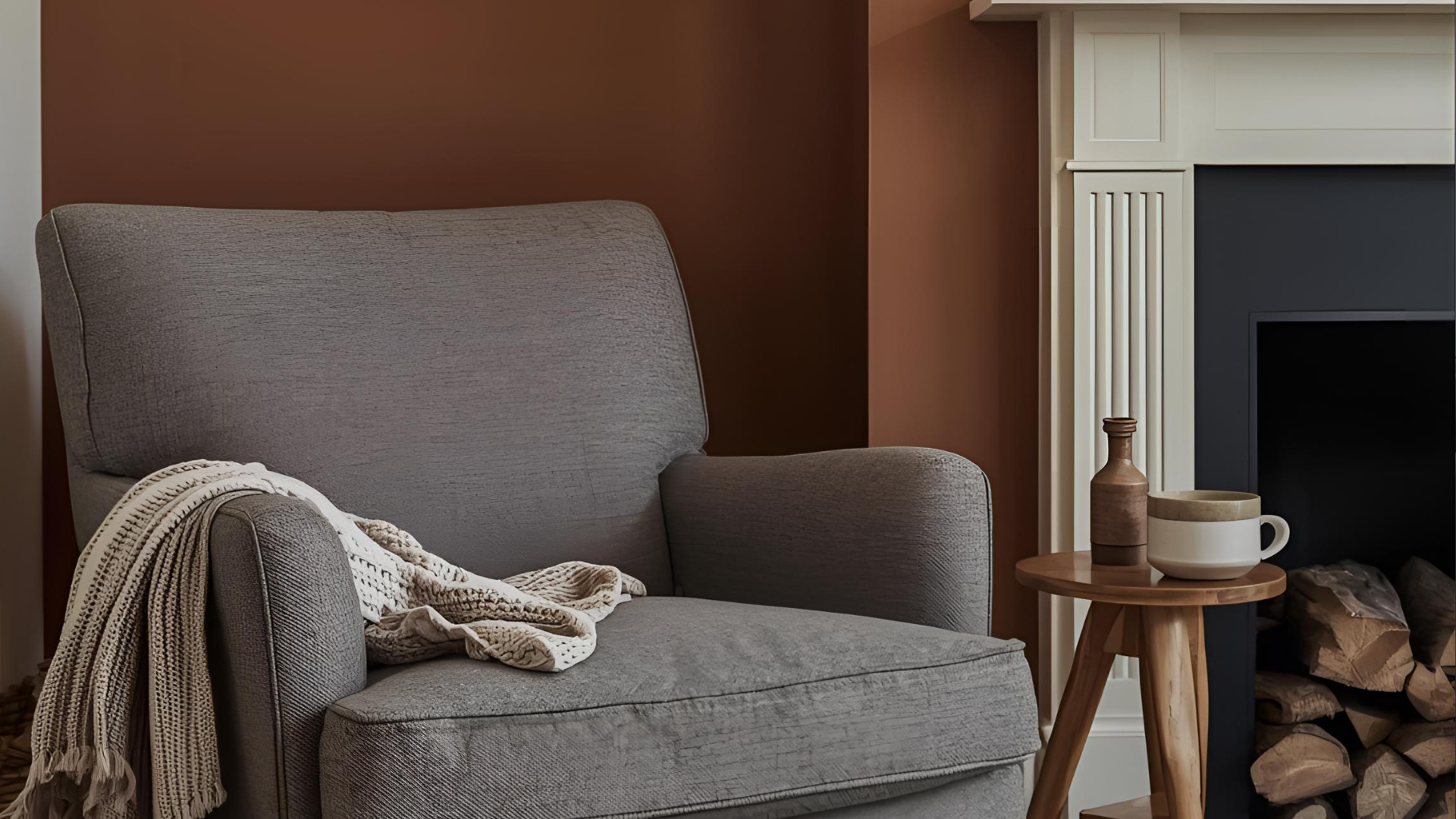 A cozy neutral chair next to a fireplace.