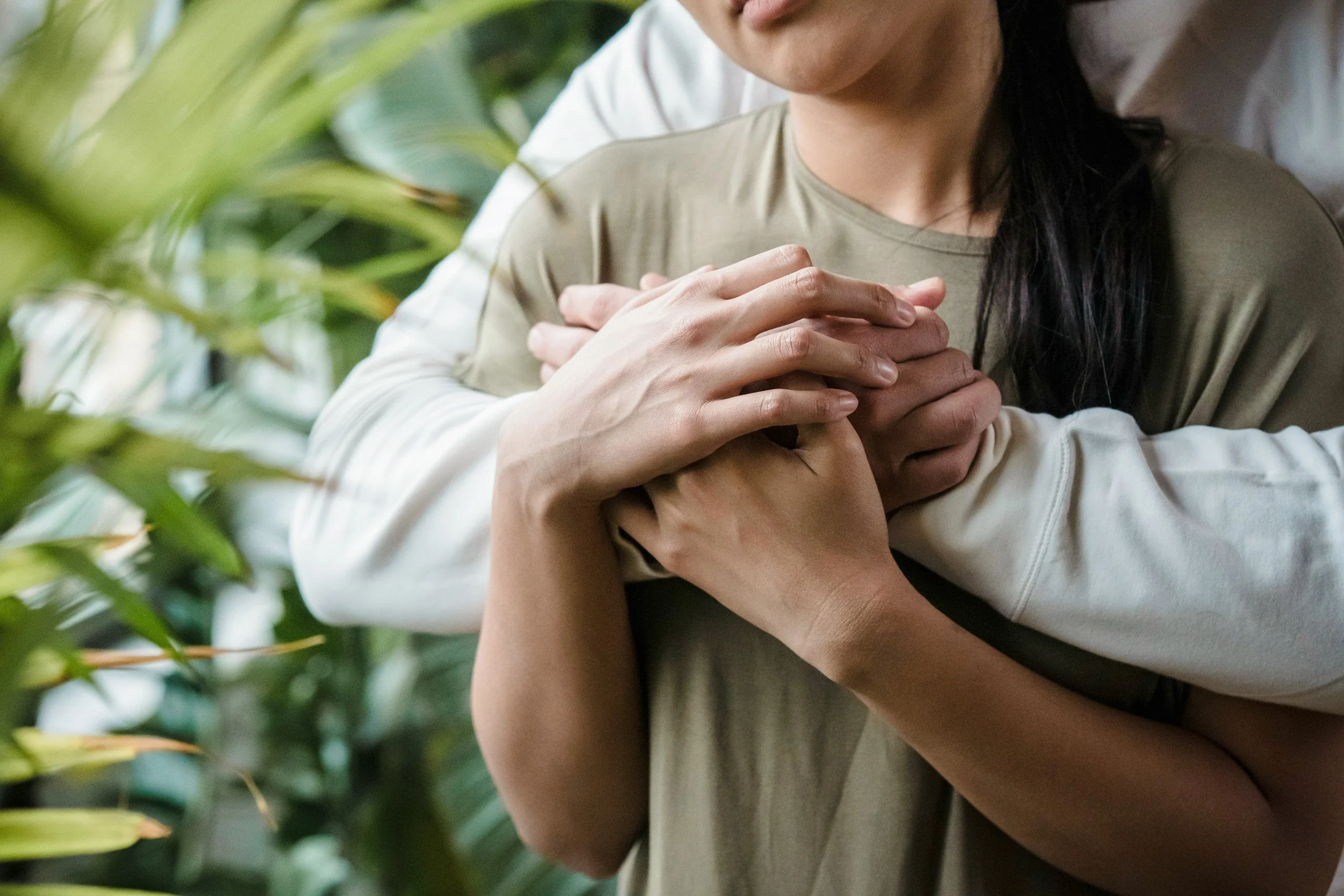 a close-up photo of a couple holding hands, utilizing the Gottman Method to improve communication, resolve conflicts, and increase intimacy