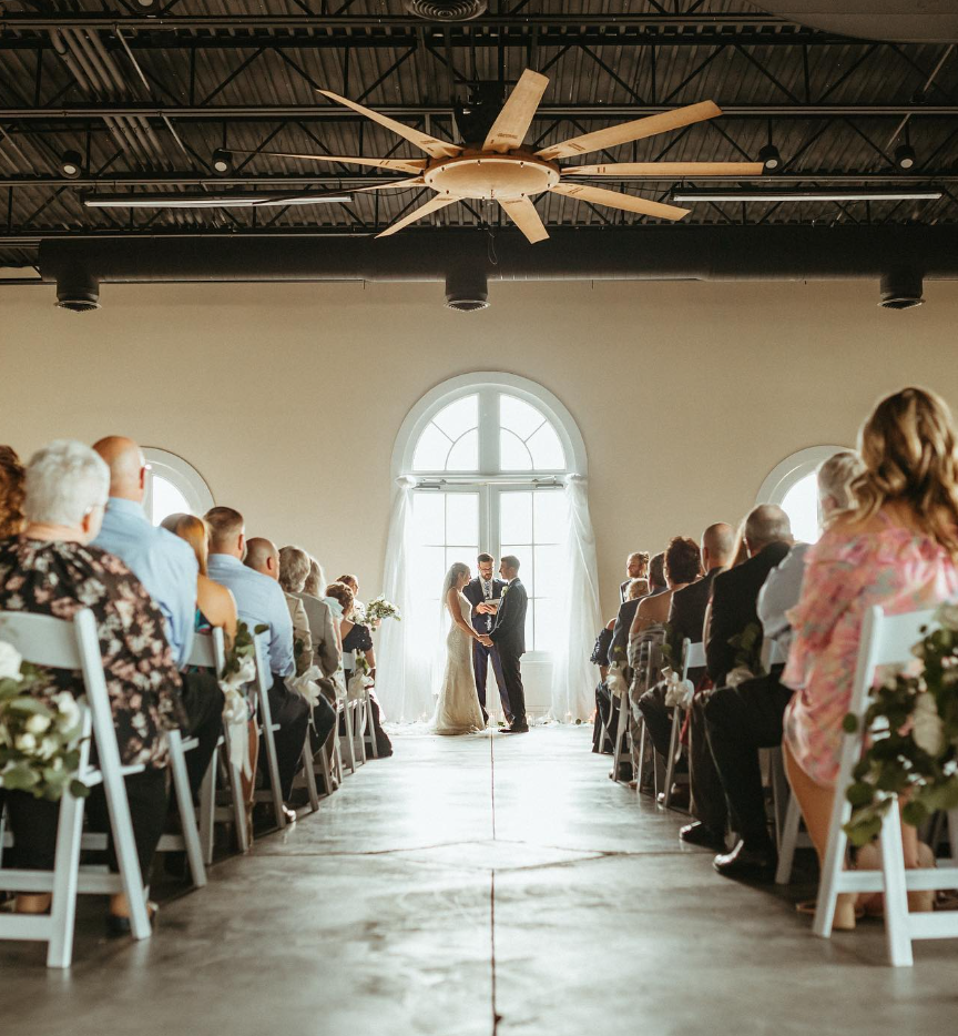 A sunlit indoor wedding ceremony setup in the modern industrial Da Vinci Room at Mellwood Art Center