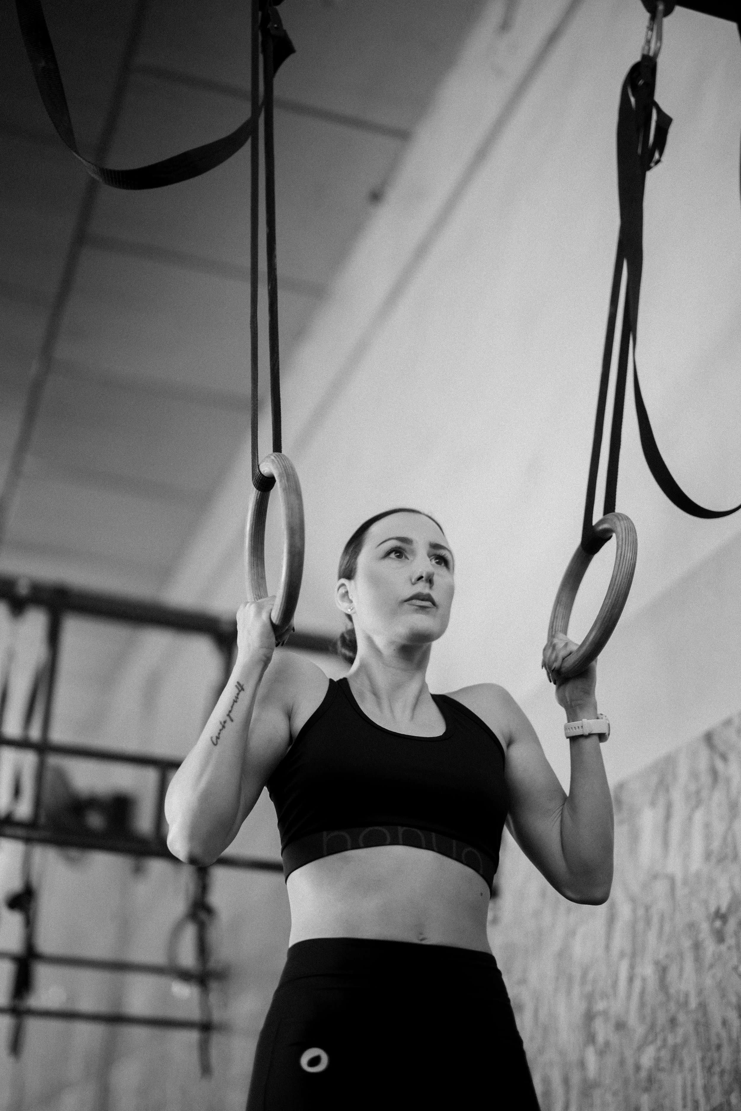 Mujer haciendo ejercicio en anillas de gimnasia en un gimnasio.
