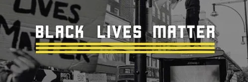 Black Lives Matter protest sign with text in black and white and yellow stripes, illustrating Karli K Coaching's values of anti-racism and social advocacy in sex and relationship coaching.