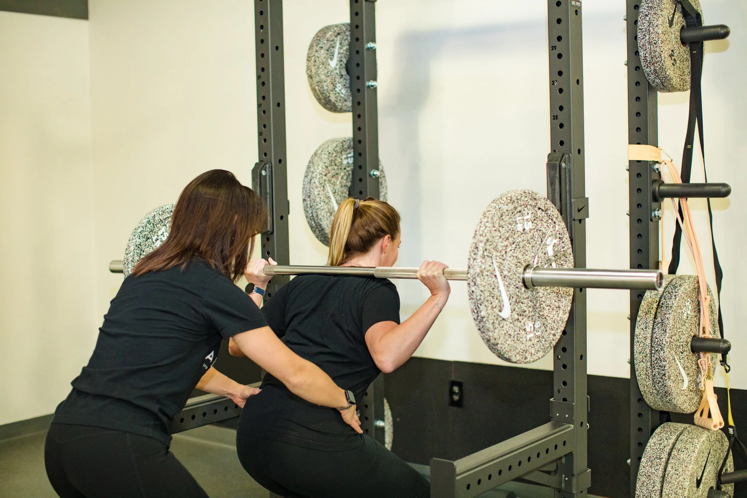 Physical therapist helping a woman squat