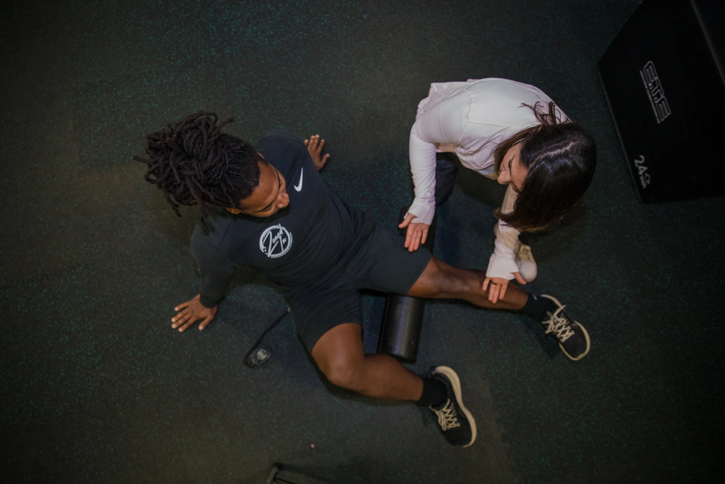 Deanna helping someone stretch using a roller